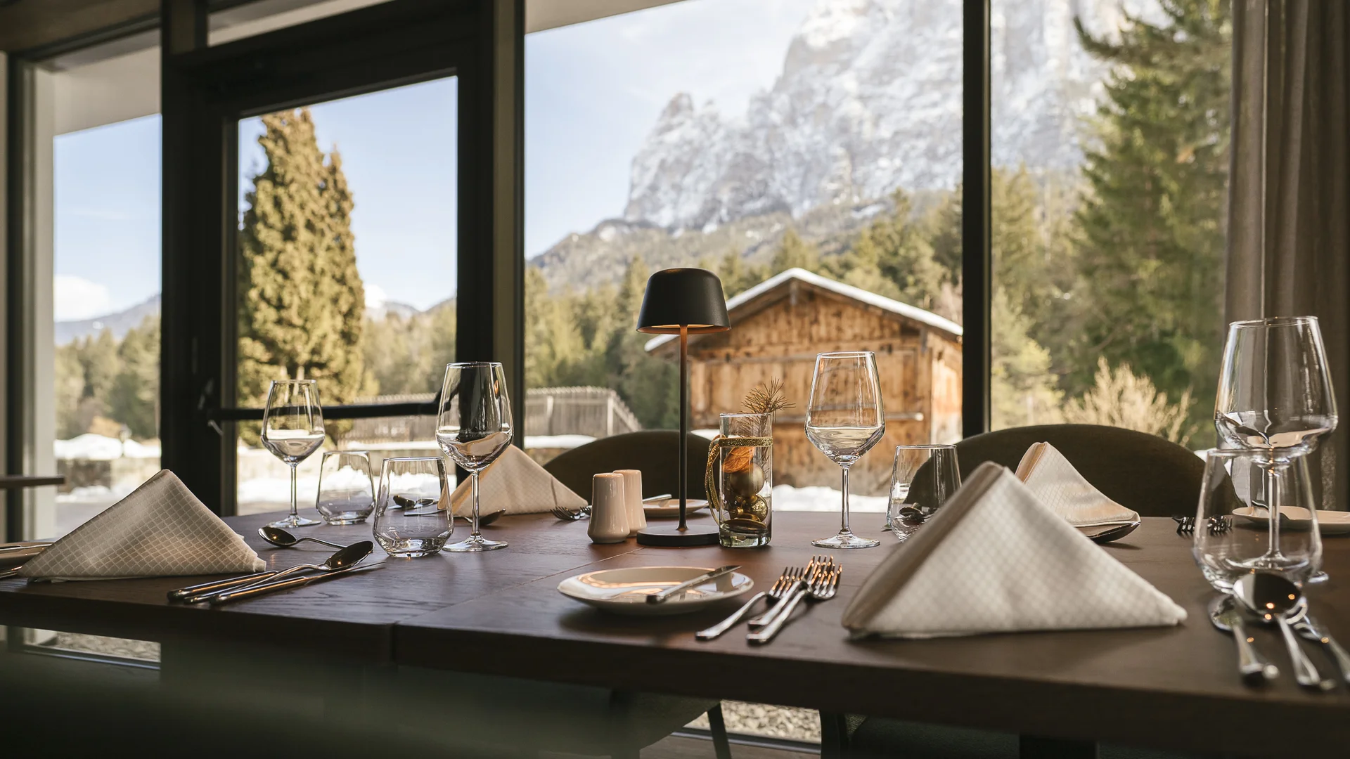 Gedeckter Tisch in Restaurant mit Bergblick und Holzhütte draußen