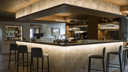 Moderner Barbereich mit beleuchteter Theke und Hockern in warmem Ambiente