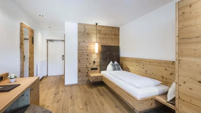 Kleines Schlafzimmer mit Holzmöbeln und Einzelbett