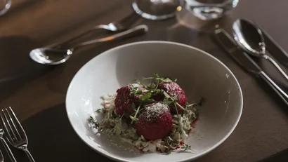 Drei rote Klöße mit Kräutern und Parmesan in weißer Schüssel