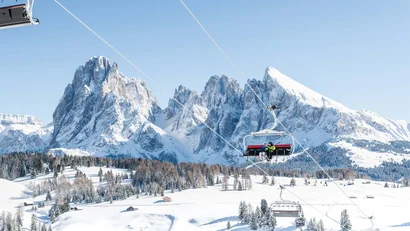 Skilift vor schneebedeckten Bergen und klarem Himmel