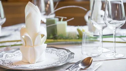 Elegante Tischdekoration mit gefaltetem Serviette und Glasgeschirr