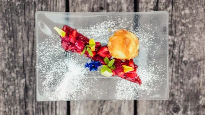 Dessert mit Beerenkompott und Vanilleeis auf rechteckigem Glasplatte