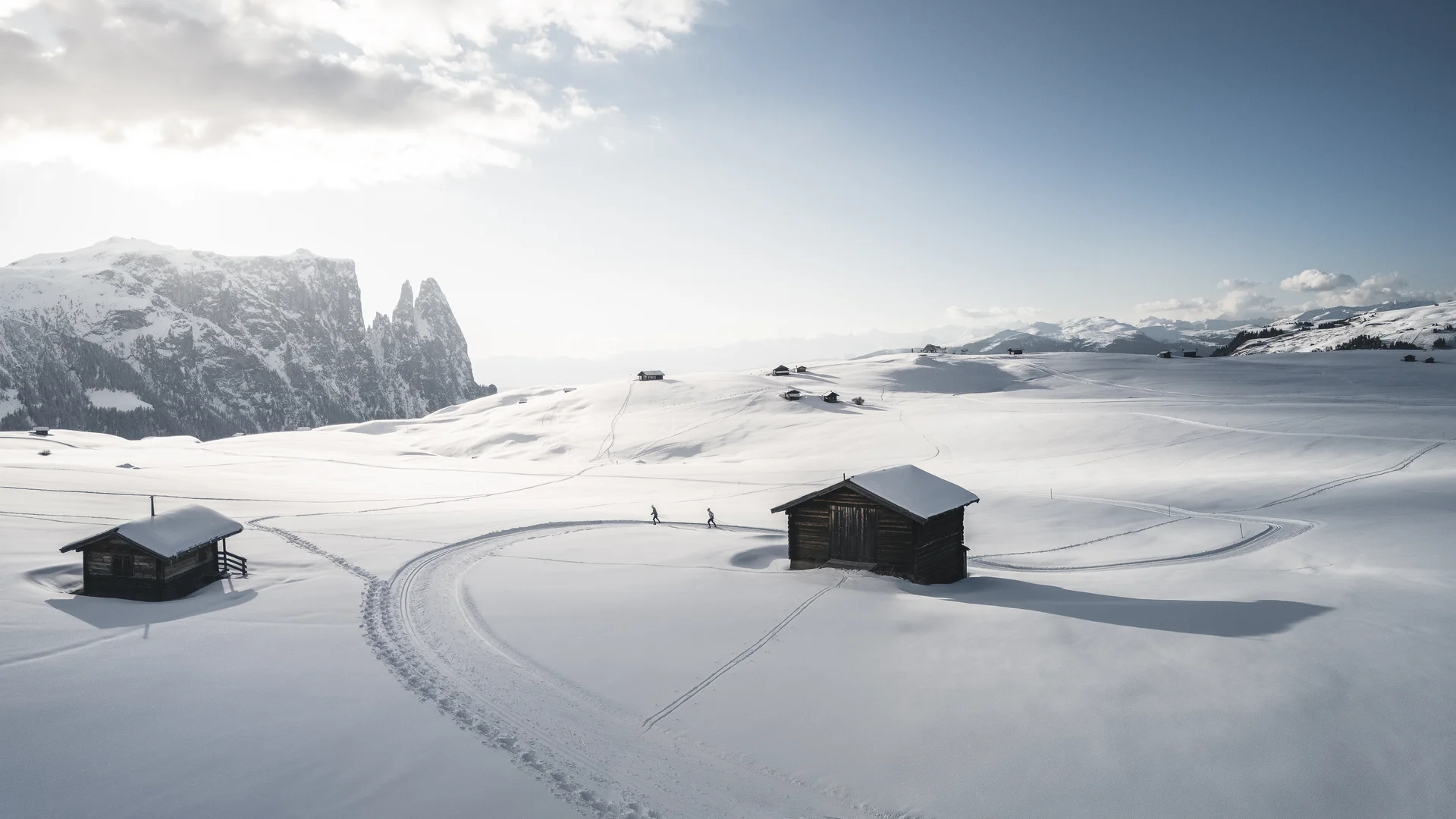 Schneebedeckte Hütten und Berge bei klarem Himmel