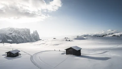 Schneebedeckte Hütten und Berge bei klarem Himmel