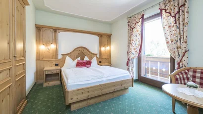 Gemütliches Schlafzimmer mit Holzmöbeln und Balkonzugang