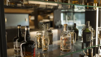 Flaschen mit Alkohol und dekorative Gläser auf Glasregalen