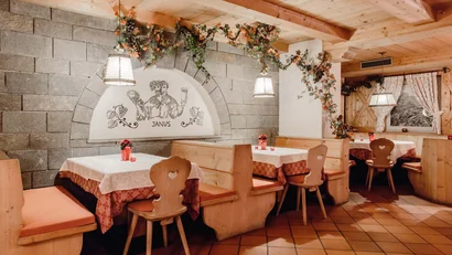 Gemütlicher Restaurantbereich mit Holzverkleidung und dekorativen Pflanzen