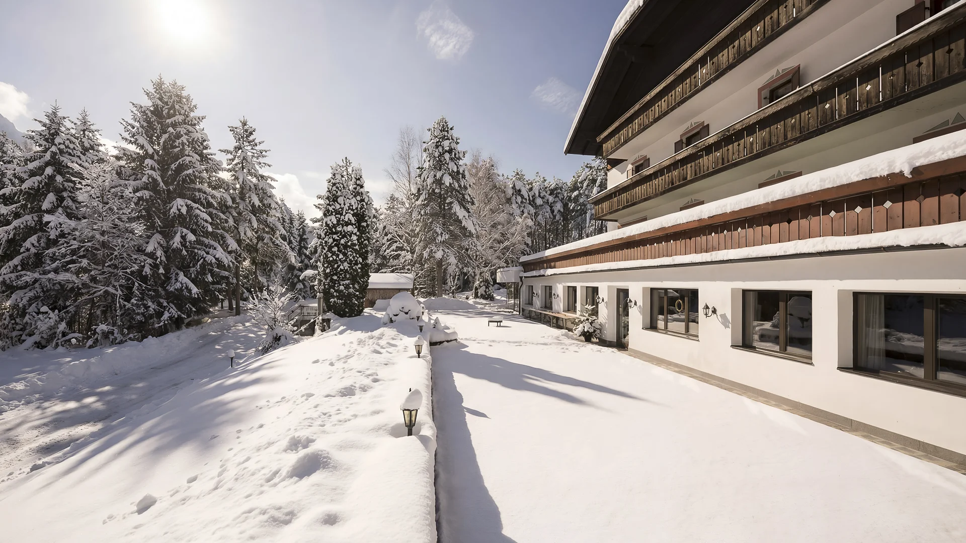 Schneebedecktes Chalet an einem sonnigen Wintertag im Wald