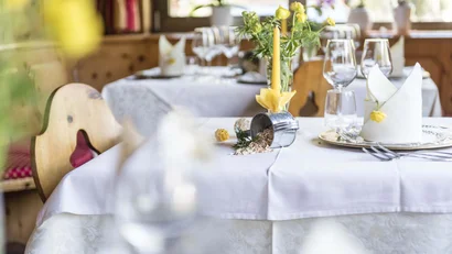 Festlich gedeckter Tisch mit gelber Kerze und Blumen im Restaurant