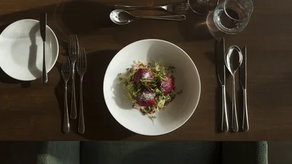 Gedeckter Tisch mit drei roter Beete knödel auf weißem Teller