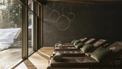 Ruheraum mit Liegen und Blick auf verschneite Landschaft